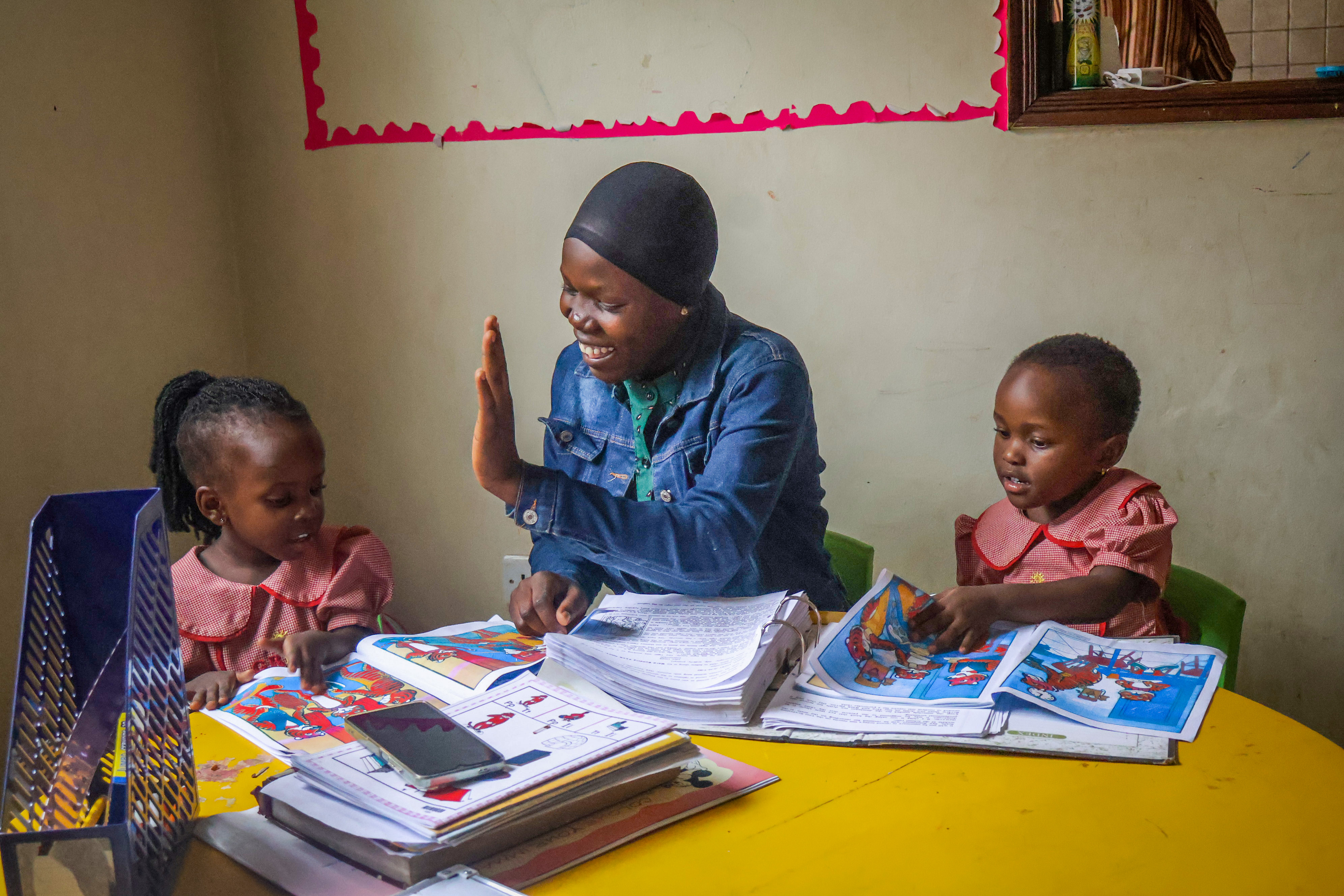 Teacher working through picture books with two young learners